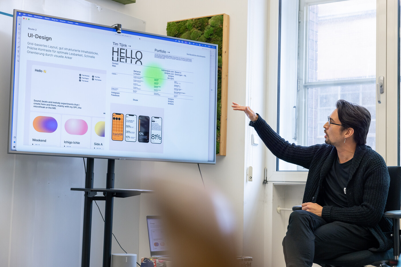 Projektleiter Danny Tuan Anh Schuster stellt bei der Fokusgruppe von engagiertes.berlin ein UI-Design auf einem Bildschirm vor und erläutert die Inhalte.