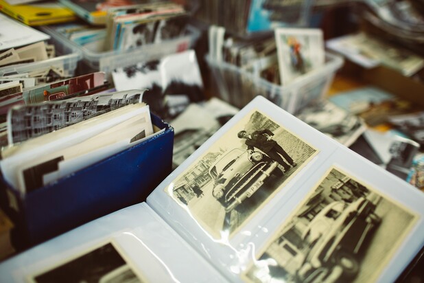 Ein aufgeschlagenes altes Fotoalbum mit historischen Fotografien von Autos.
